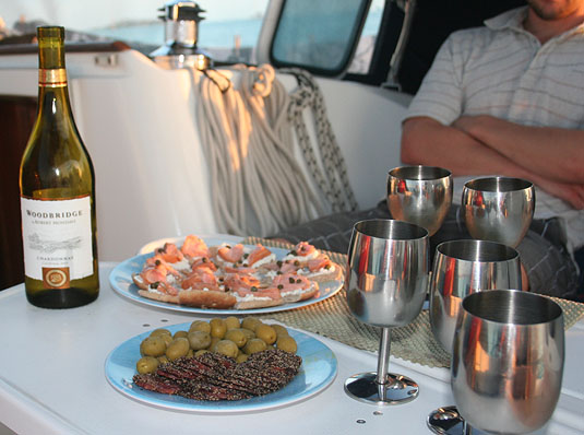 A fancy happy-hour with white wine, black pepper dry sausage, green olives and smoked salmon canapés.