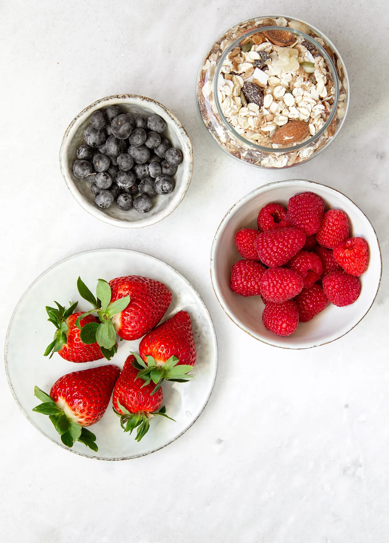 Bowl of rolled oats with a variety of berries, the ingredients required to make Maple Berry Overnight Oats // FoodNouveau.com