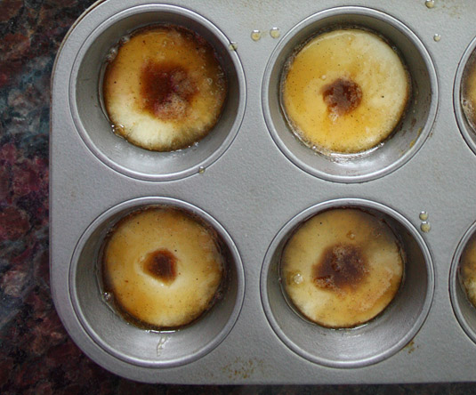 Distribute one apple slice into the base of each muffin mold, then top with the caramel mixture.