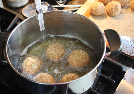 Making Arancine con Ragù: To fry the rice balls: When the oil comes to temperature, carefully slip 4 or 5 rice balls into the oil (don’t overcrowd the pot). Fry, turning as necessary with tongs or a slotted spoon, until golden brown and crisp on all sides, about 4 minutes. 