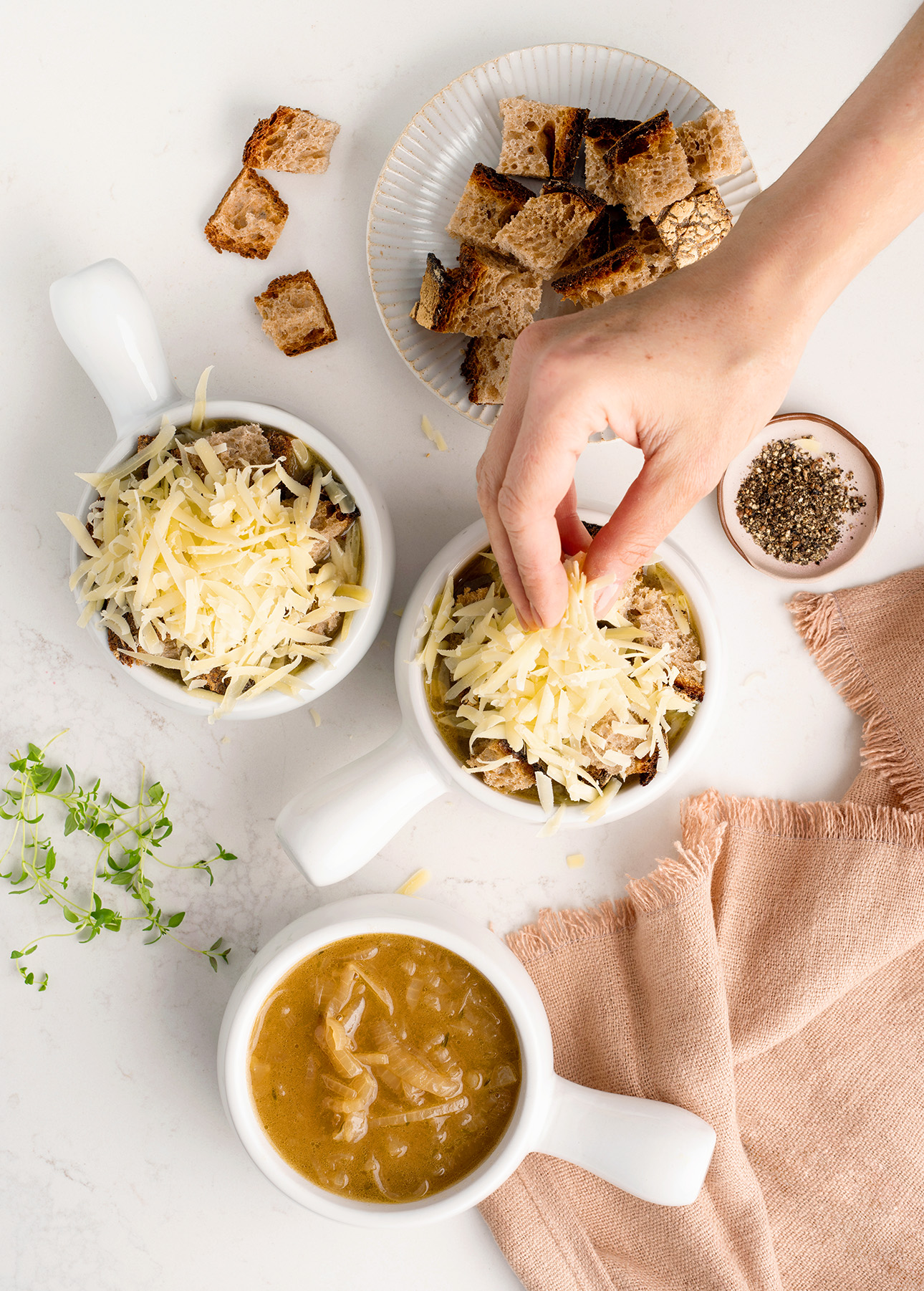 Adding croutons and grated cheese to classic French onion soup // FoodNouveau.com