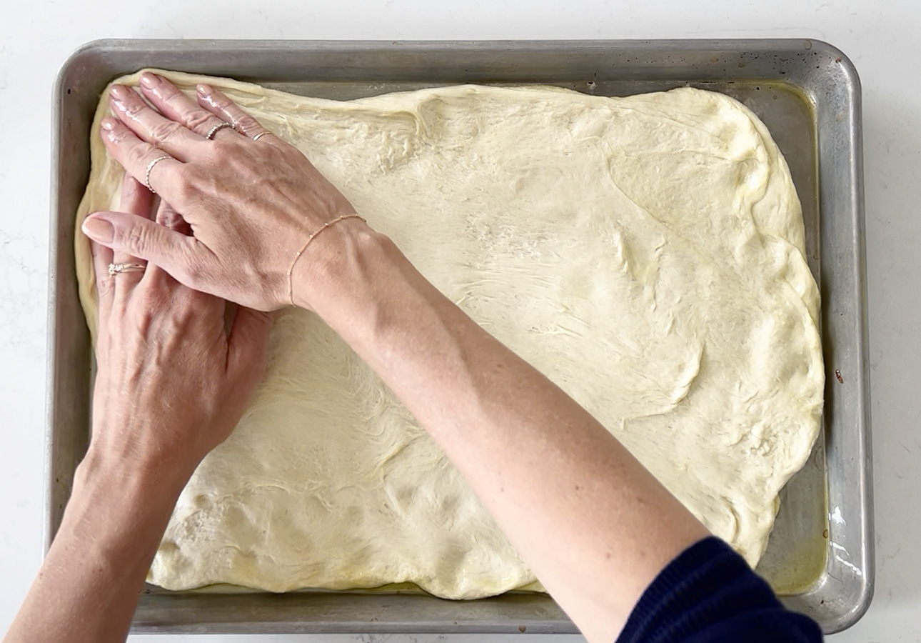 Spreading dough to make pissaladière, a French flatbread // FoodNouveau.com