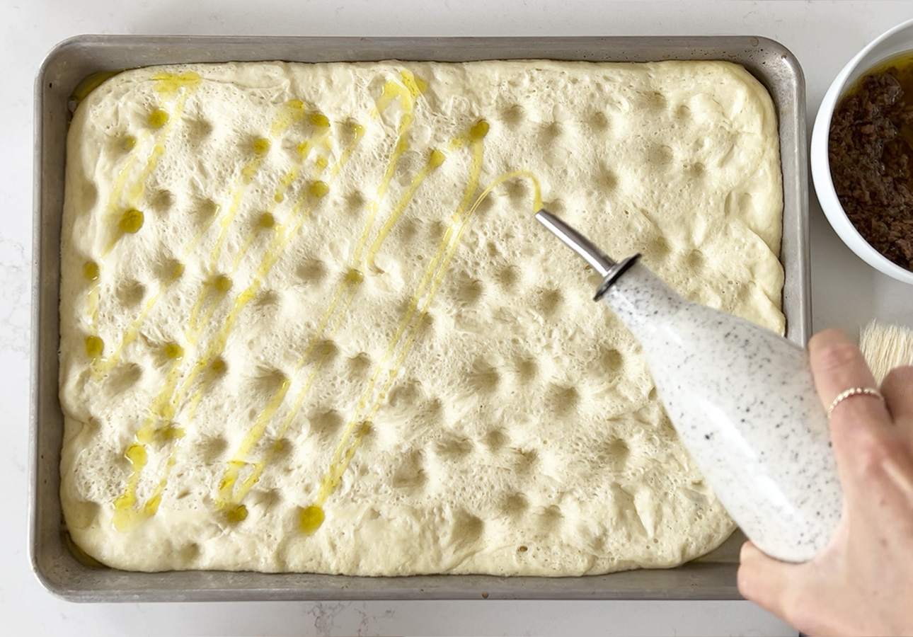 Drizzling pissaladière dough with extra-virgin olive oil // FoodNouveau.com