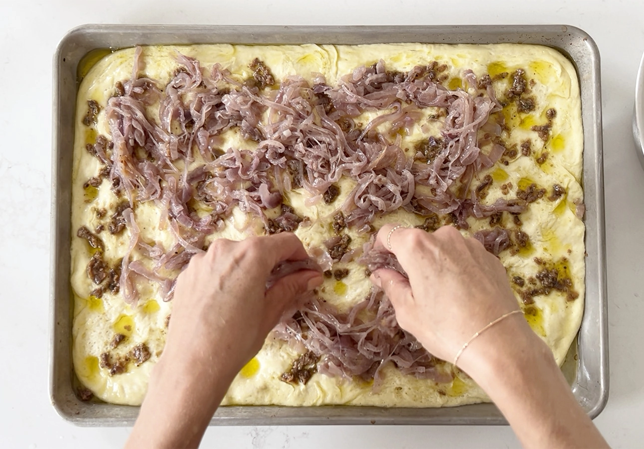 Adding caramelized onions over flatbread dough // FoodNouveau.com